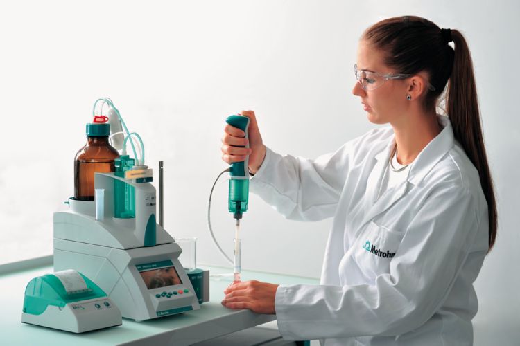 Female laboratory personnel pipetting using an 865 Dosimat plus with manual push-button cable, 63026220 Exchange Unit 20 mL, Magnetic Stirrer 801 Stirrer, Neo's printer, 61562060 Pipetting equipment for Manual Dosing Controller and 61562140 Pipetting tubi