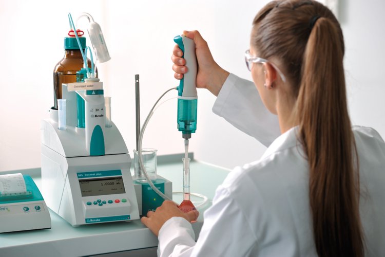 Female laboratory personnel pipetting using an 865 Dosimat