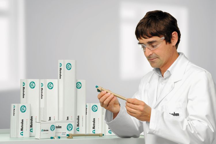 man holding an IC column in his hands, more IC column packages in the background on a table