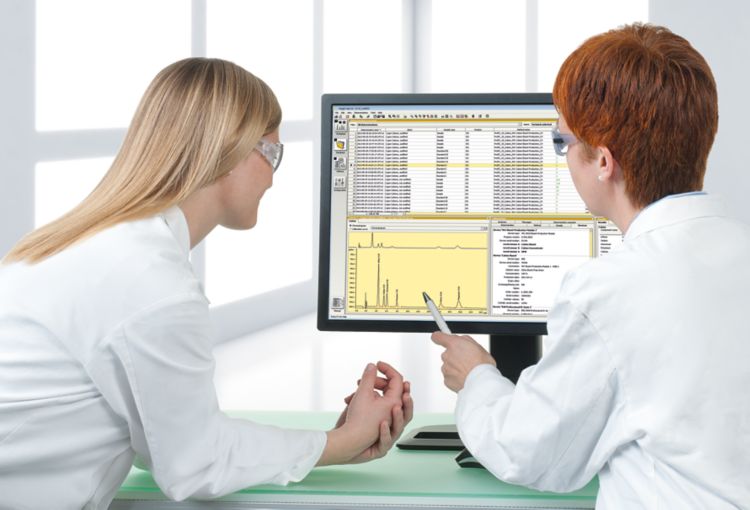 Duas profissionais analizando dados em uma tela de computador.