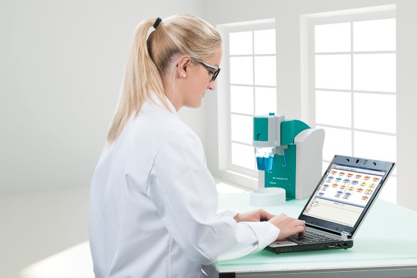 female lab worker with 894 Professional CVS manual, 28940210, laptop, viva software