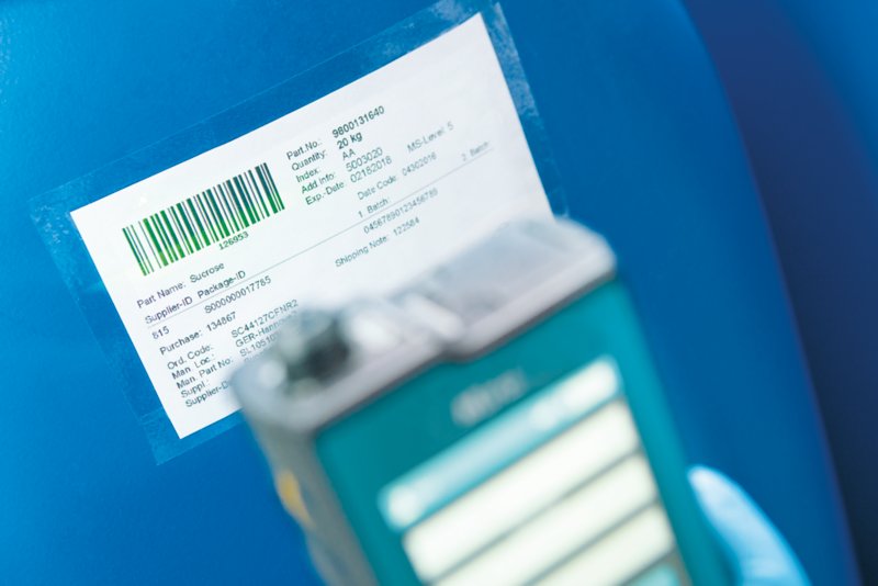 Equipamento portátil Raman desfocado, com enfoque em um código de barras.