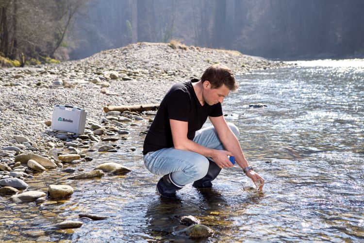 946 Portable VA Analyzer, male operator sampling at a river (carrying case 6.02707.010)