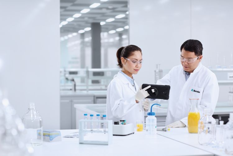Dwóch naukowców w laboratorium testuje próbki żywności za pomocą MISA i sprawdza wyniki na tablecie.