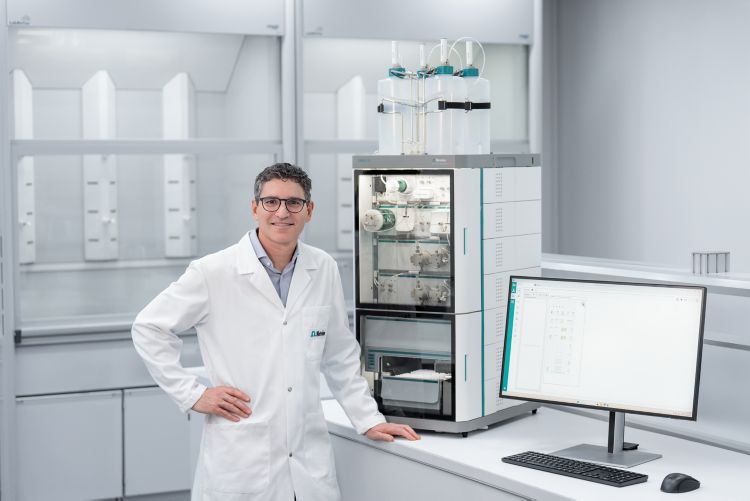 Man in a lab in front of OMNIS IC and laptop with OMNIS Software
