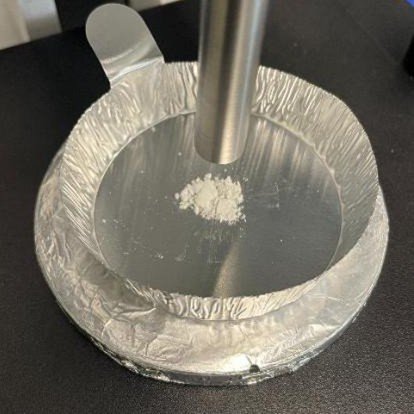 Precipitate recovered from the reaction and mounted on a BAC151B probe holder for Raman analysis.