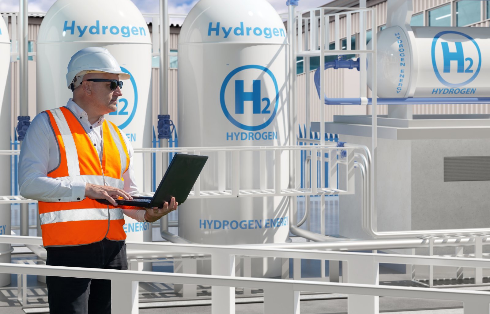 Man works for energy company. Engineer stands among hydrogen equipment. Mechanic with laptop controls process of obtaining energy. Man inspects hydrogen power plant. Getting electricity from hydrogen H2