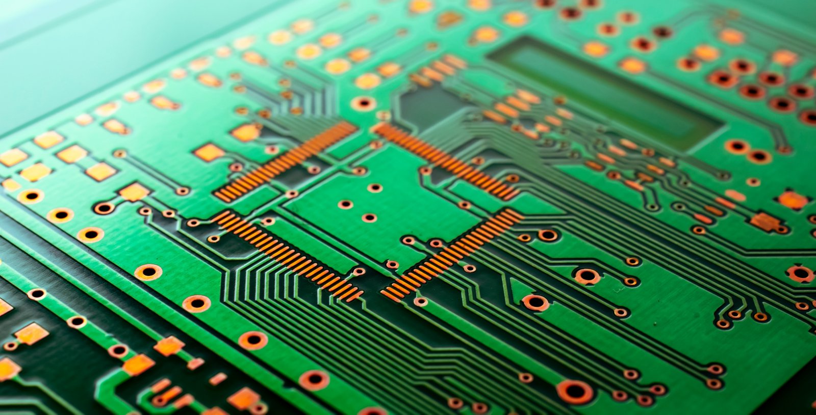 Beispiel einer Leiterplatte (PCB) mit verschiedenen Komponenten wie bspw. Leiterbahnen, Lötpads und Bohrungen (Vias).