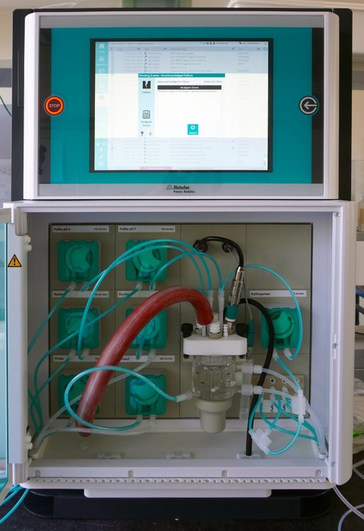 Eksperymentalna konfiguracja w Merck KGaA: analizator procesowy 2060 TI do w pełni automatycznego oznaczania wartości pH, z systemem grzewczym, w celu zapewnienia stałej temperatury zdefiniowanej od momentu pobrania próbki do analizy.